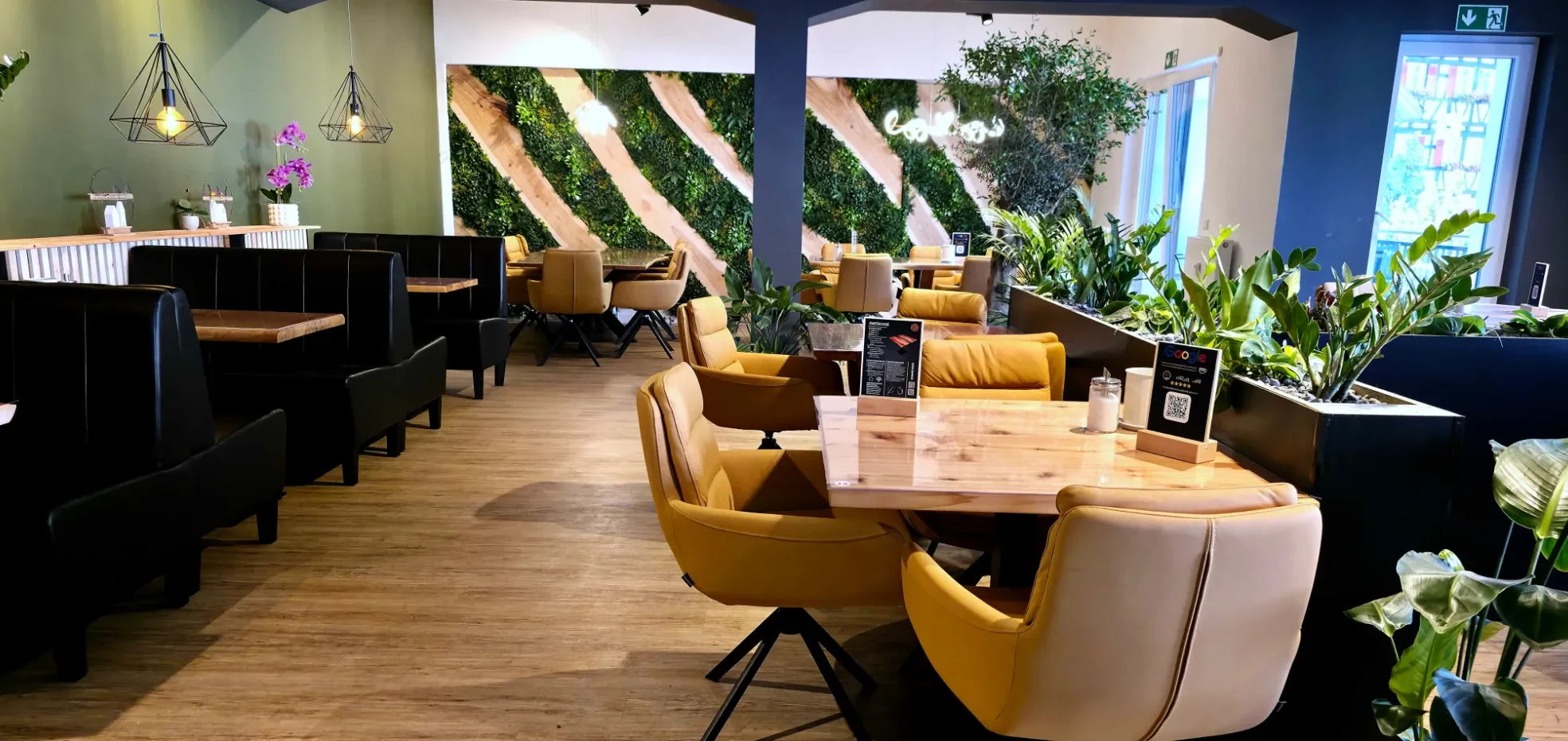 HolzZeit Café Obergeschoss Gemütliches Café mit modernen Möbeln und Pflanzen, warmes Farbkonzept.