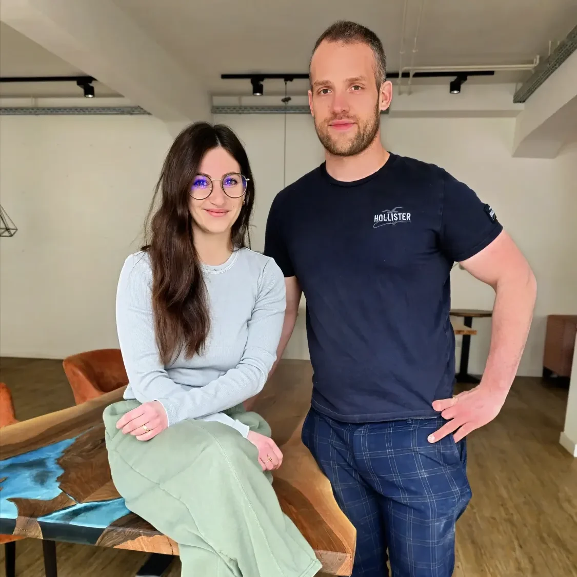 Die Gründer stehen entspannt im modernen Café vor einem Tisch