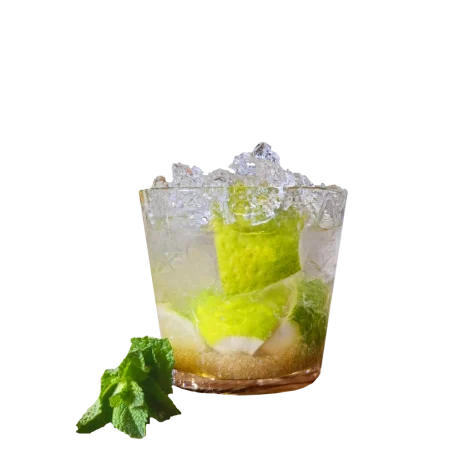 Caipirinha im Glas mit Limettenstücken und Crushed Ice.